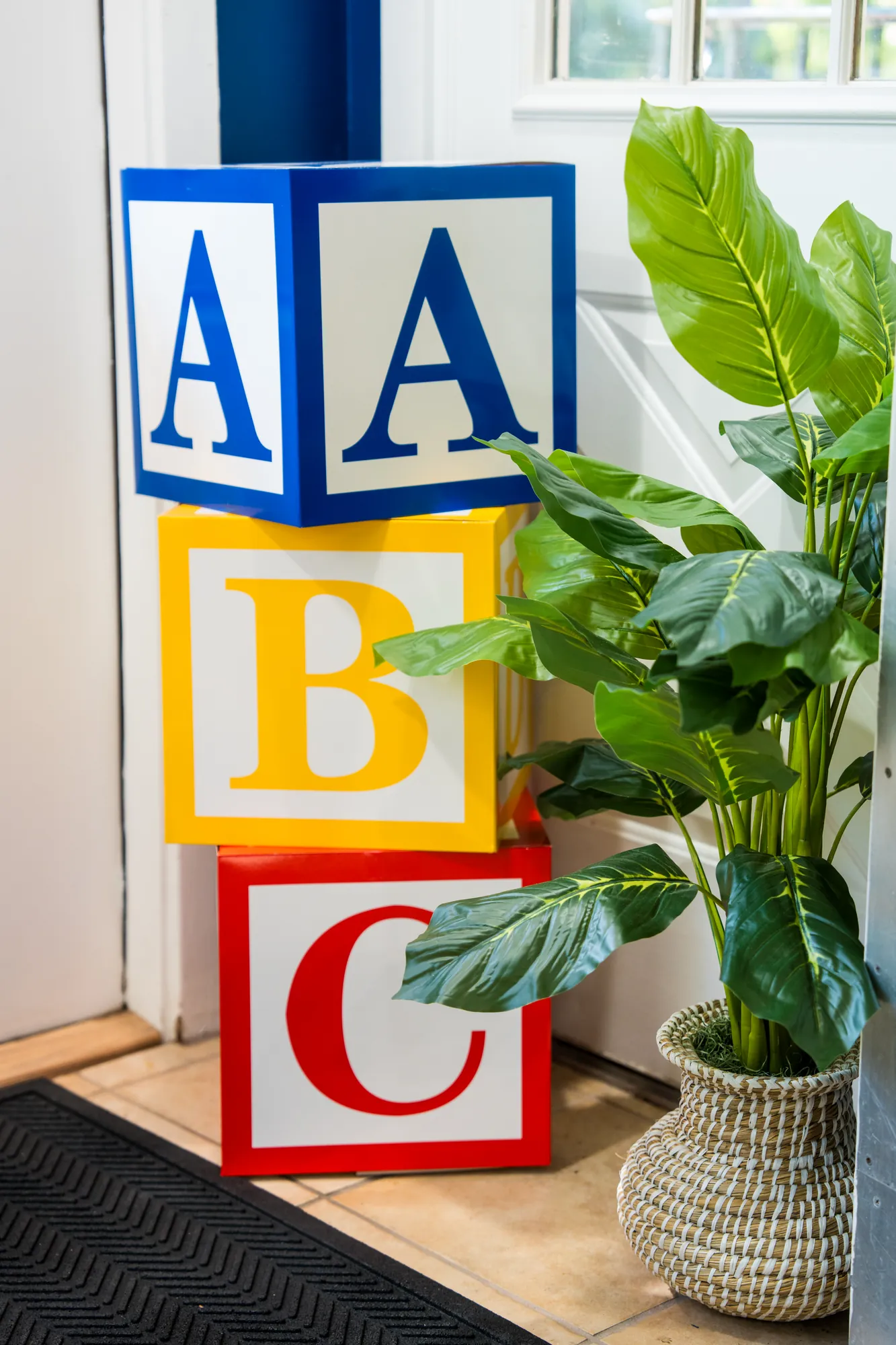 Oversized ABC blocks and a potted plant by the school entrance
