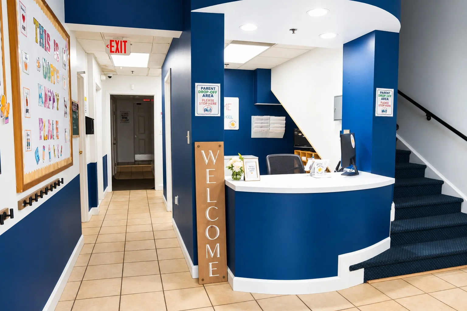 The entry hallway, the welcome desk, and the stairs to the upper classrooms
