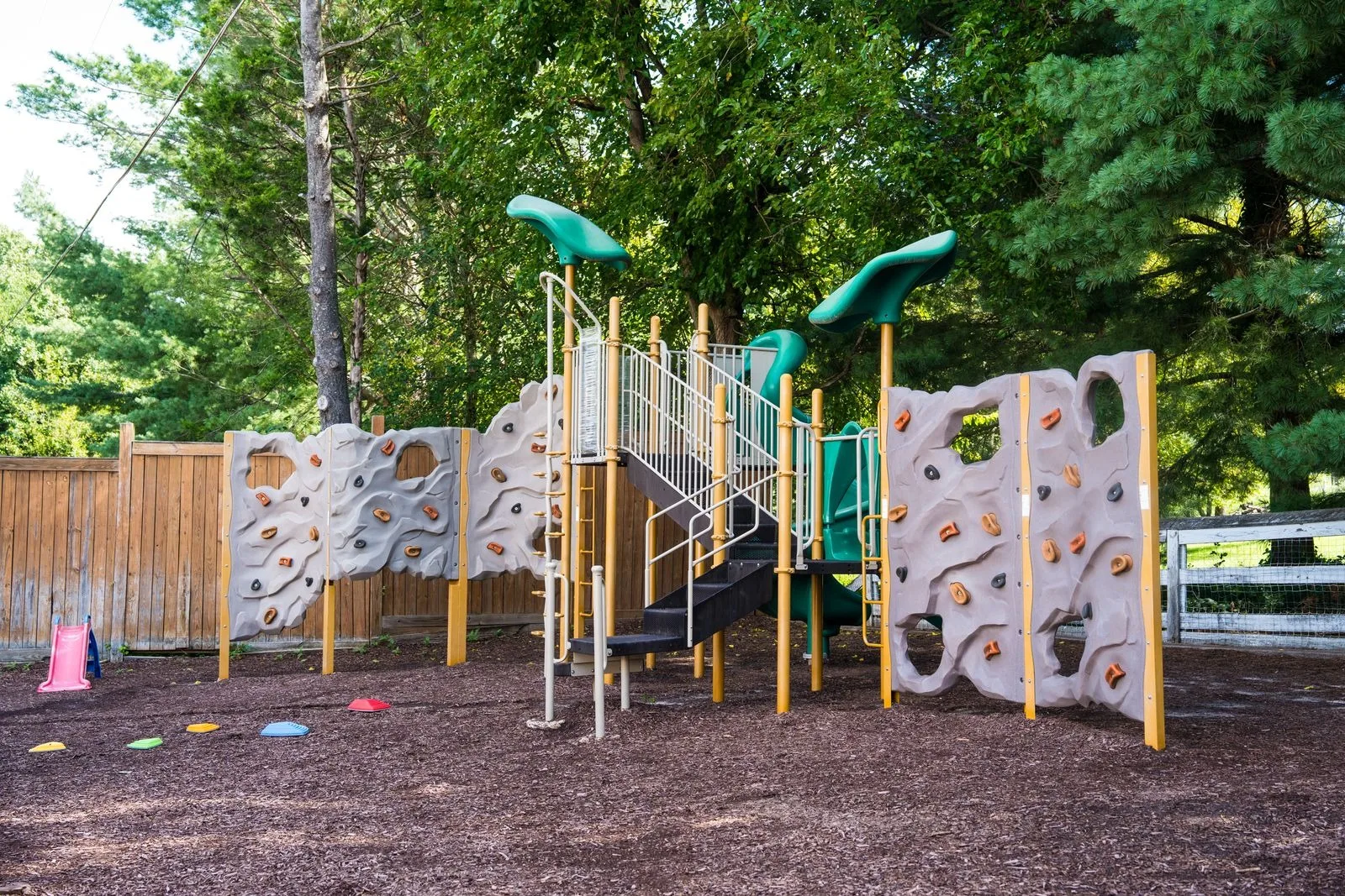 The climbing structure with rock walls, ladders, and a tunnel slide