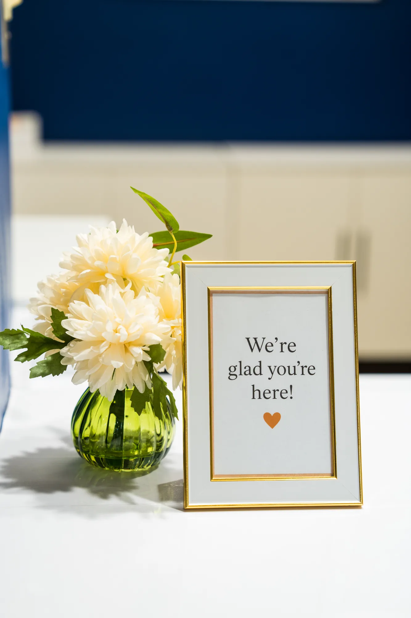 Fresh flowers and a "We’re glad you’re here!" card on the welcome desk